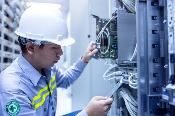 Techniker überprüft elektrische Anschlüsse in einem Schaltschrank.