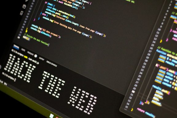 Ein Bildschirm mit Codezeilen und der Aufschrift "HACK THE WEB".